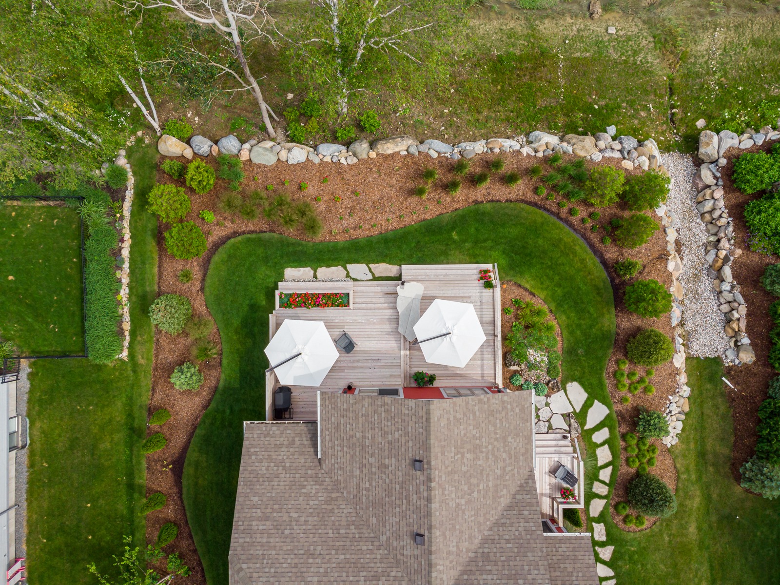 Aerial view of landscaped backyard with wooden deck