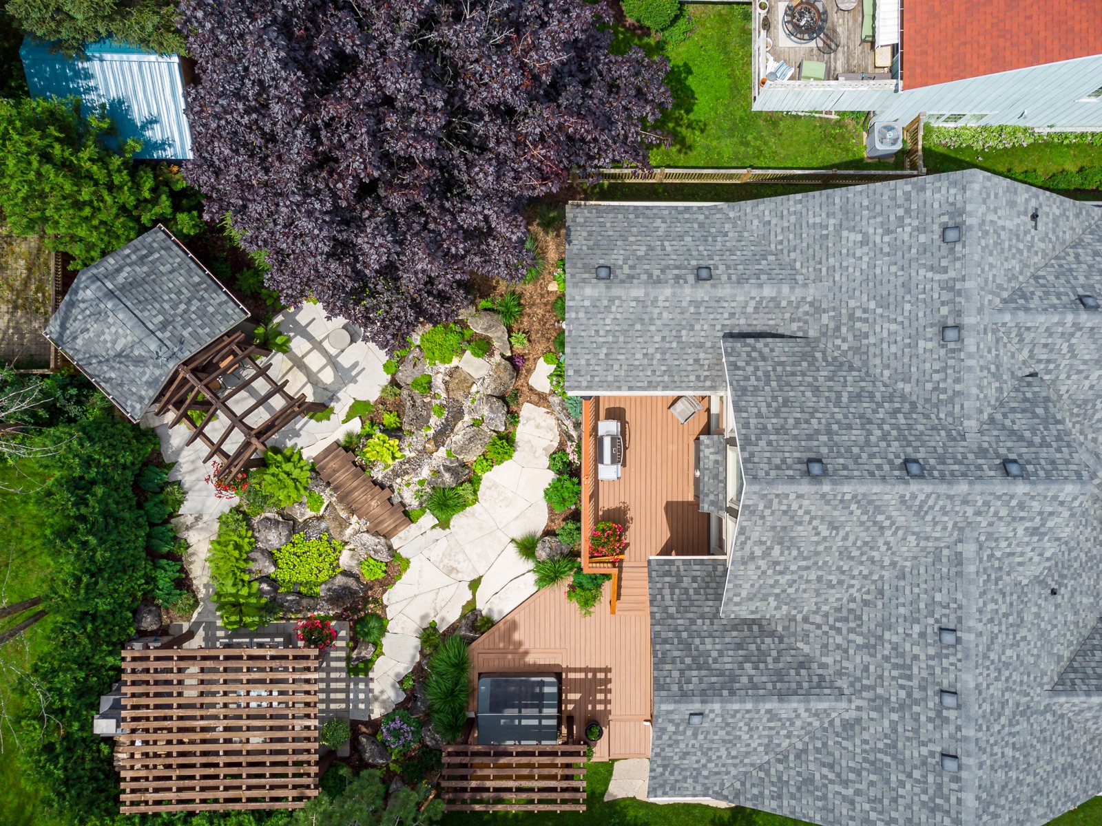 Aerial view of landscaped backyard with deck and pergola