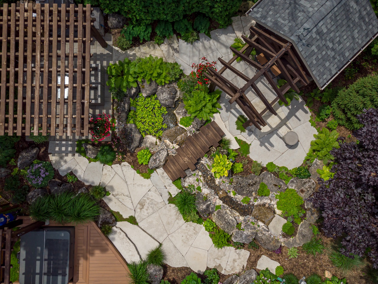 Aerial view of landscaped garden with pergola and pond