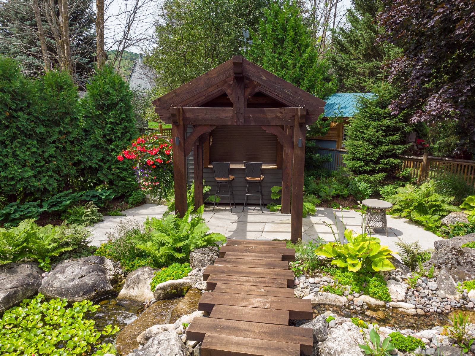 Wooden pergola bar in landscaped backyard garden