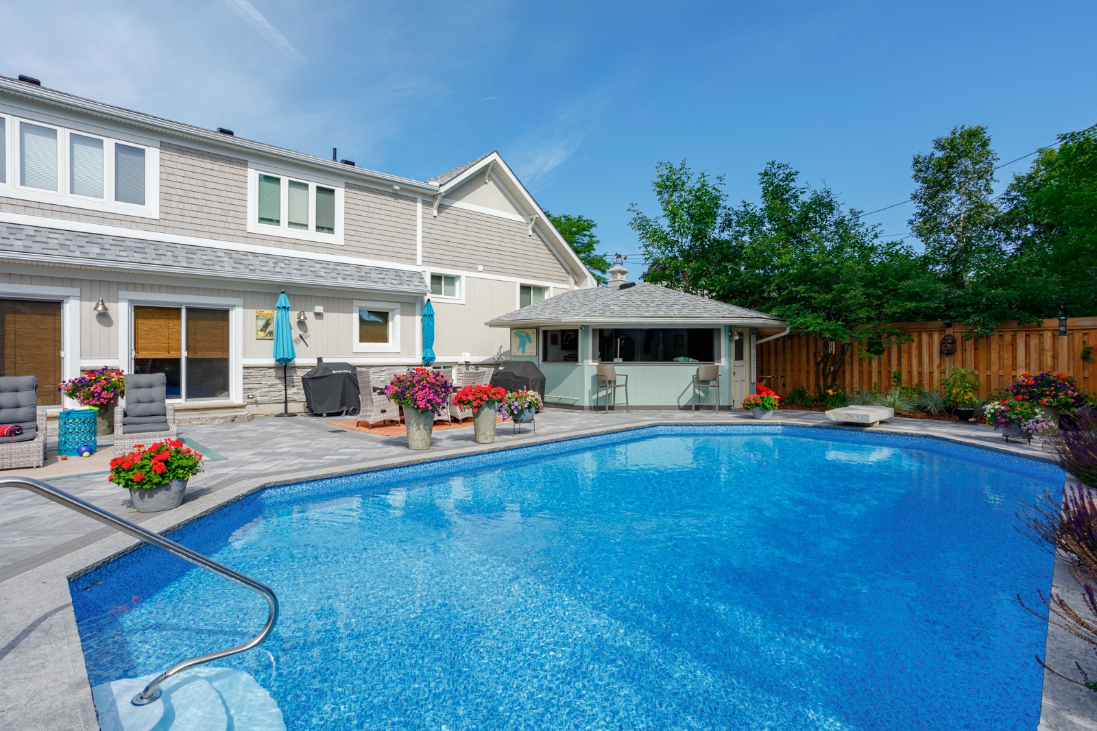 Backyard swimming pool with patio and pool house
