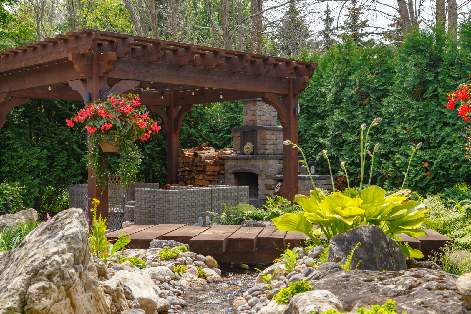 Backyard pergola with fireplace and garden stream
