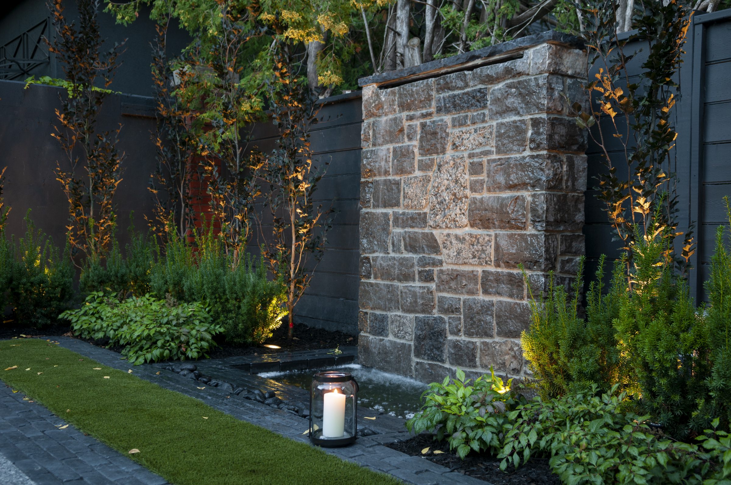 Modern stone water feature in landscaped garden