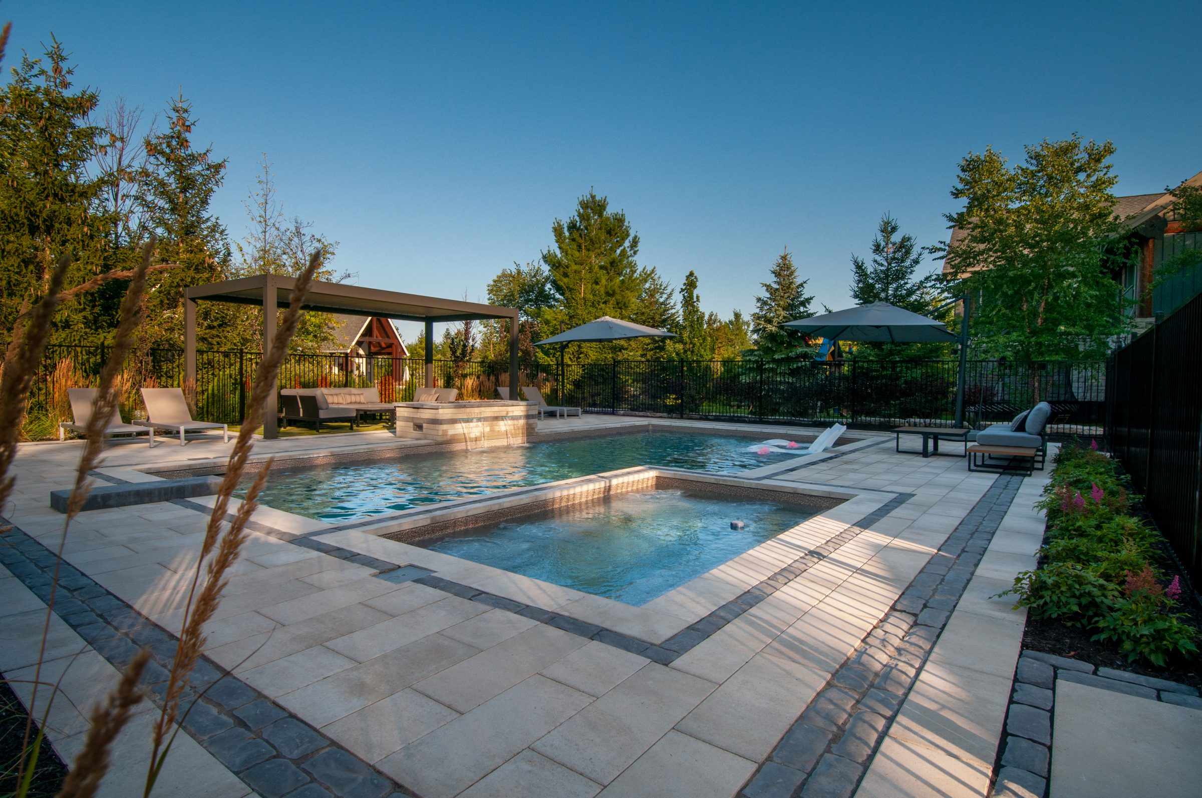 Modern backyard pool with hot tub and lounge area