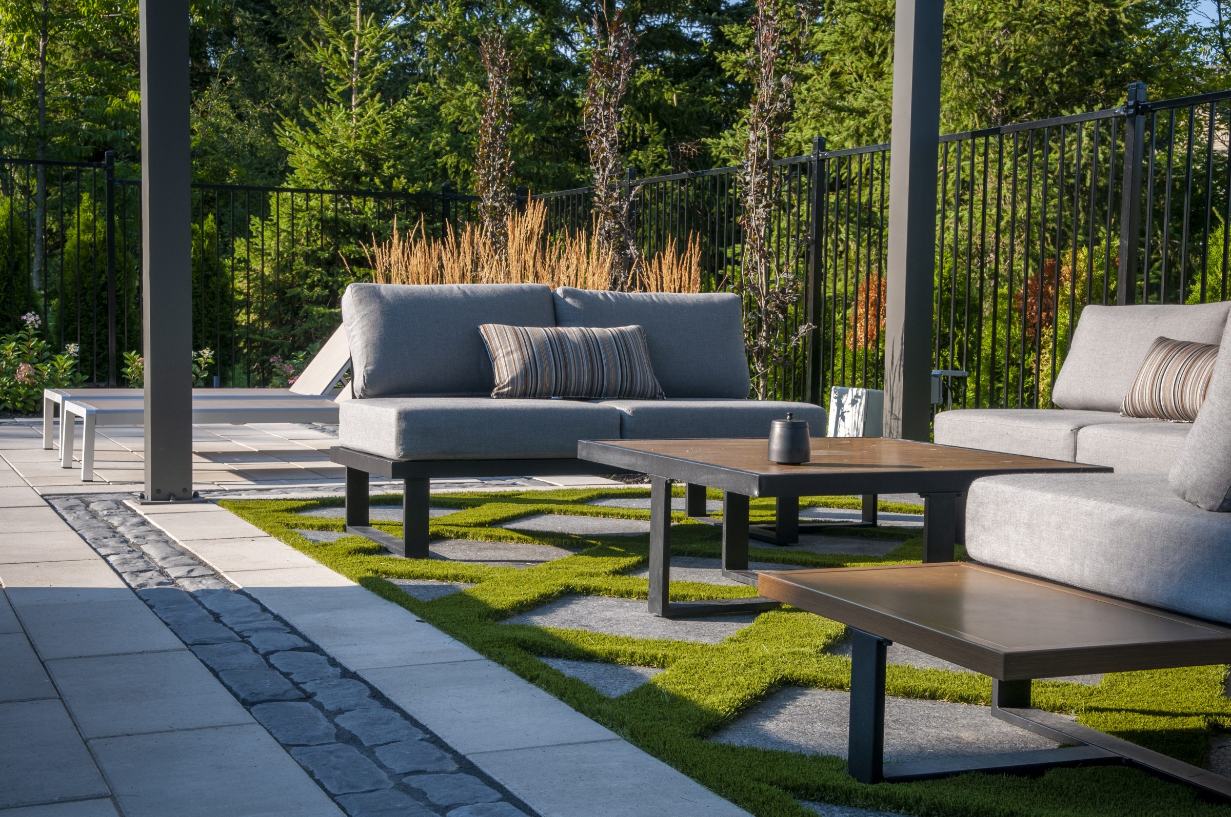 Modern outdoor patio with gray sofas and tables