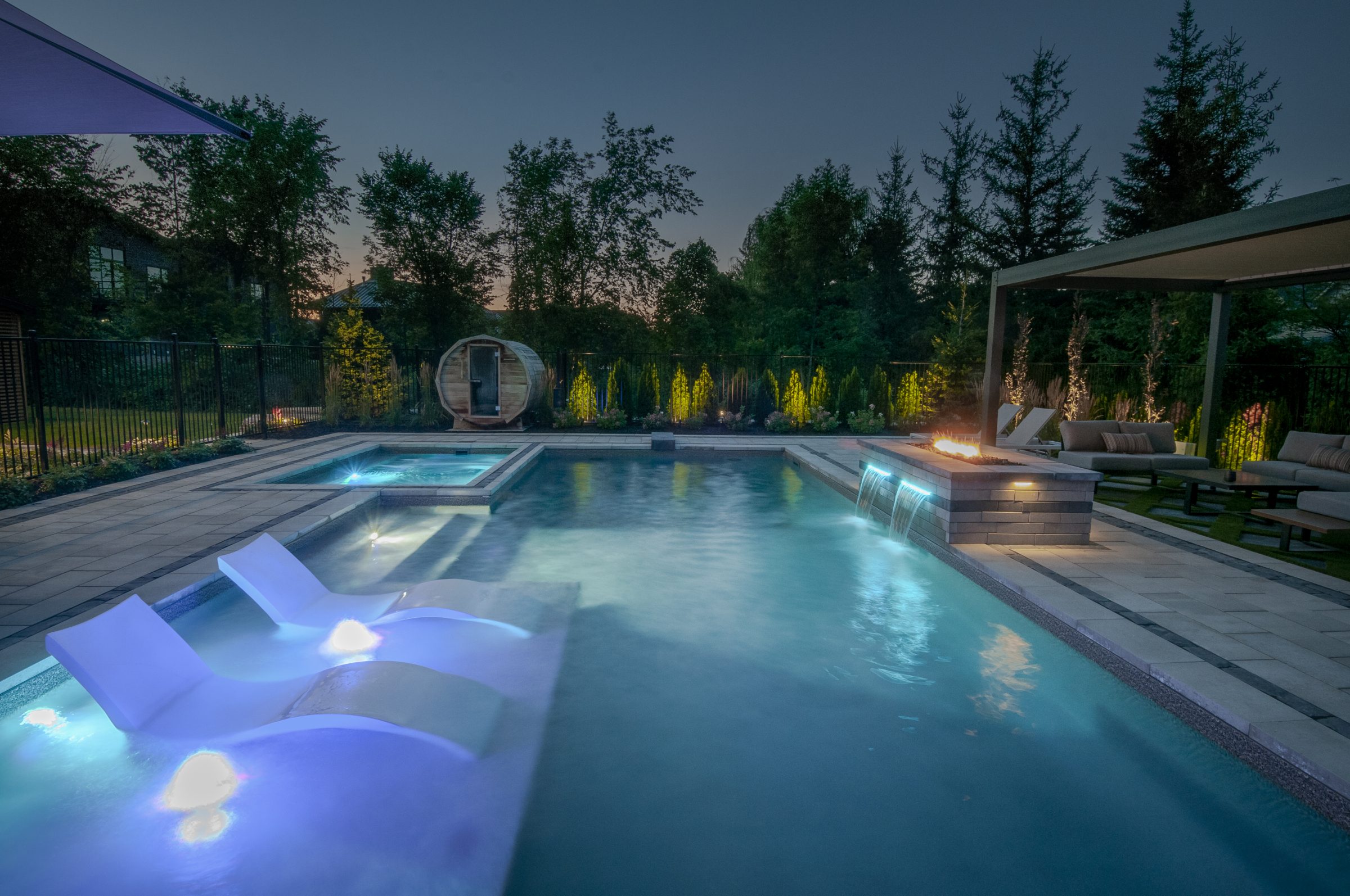 Luxury backyard pool with fire feature at dusk