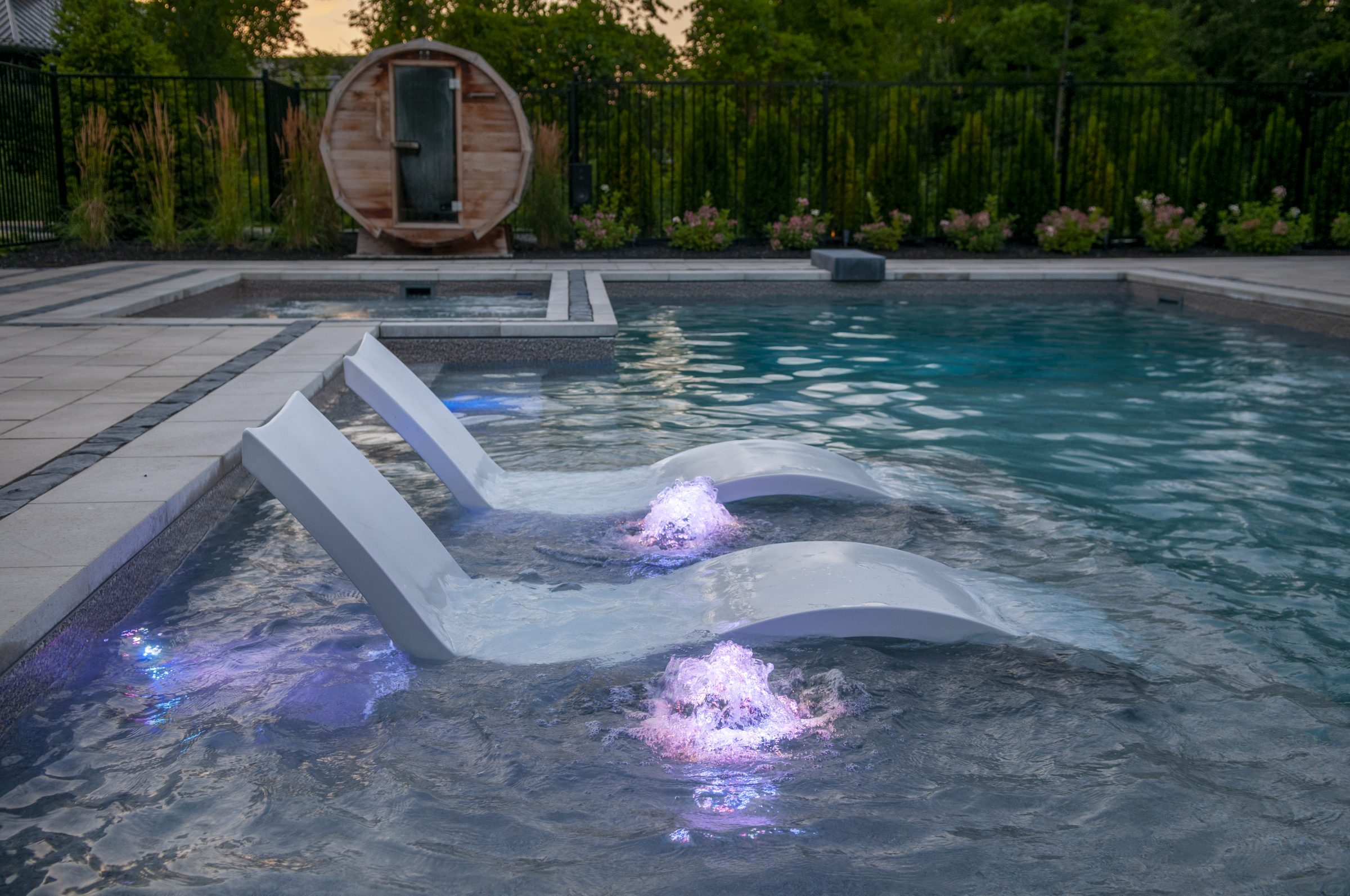 Modern backyard pool with in-water lounge chairs