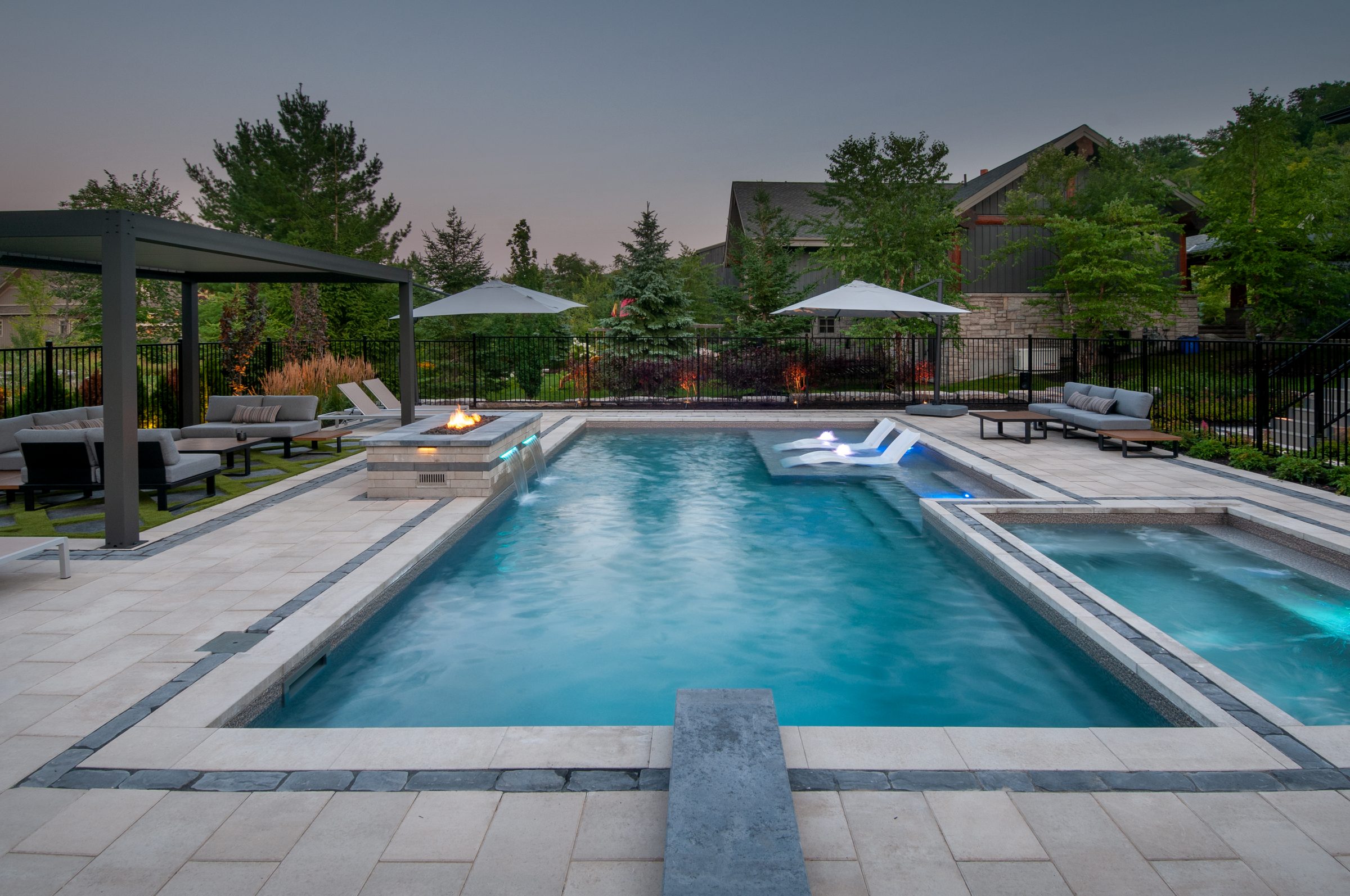 Modern backyard pool with spa and fire feature