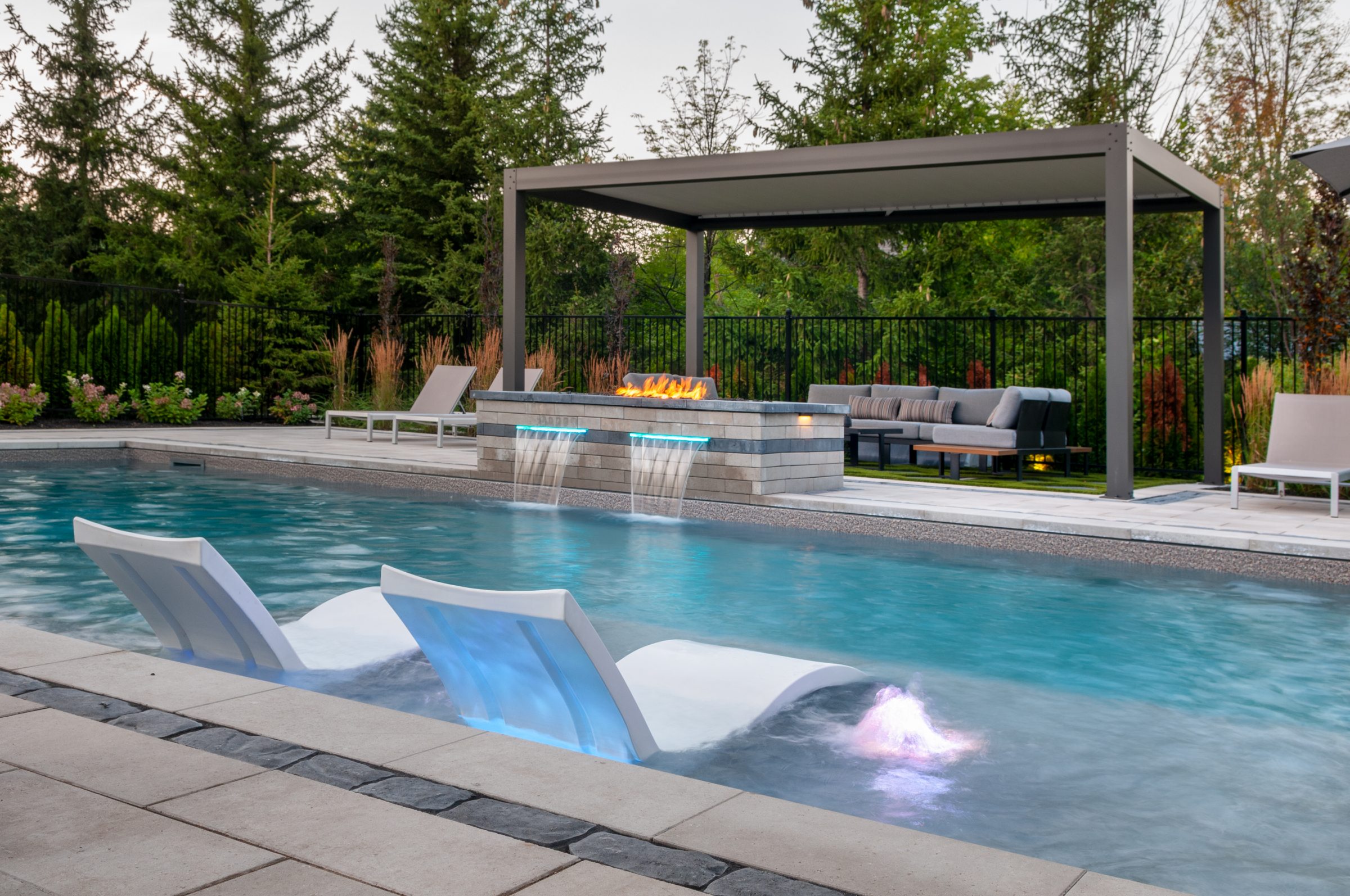 Modern backyard pool with fire feature and pergola