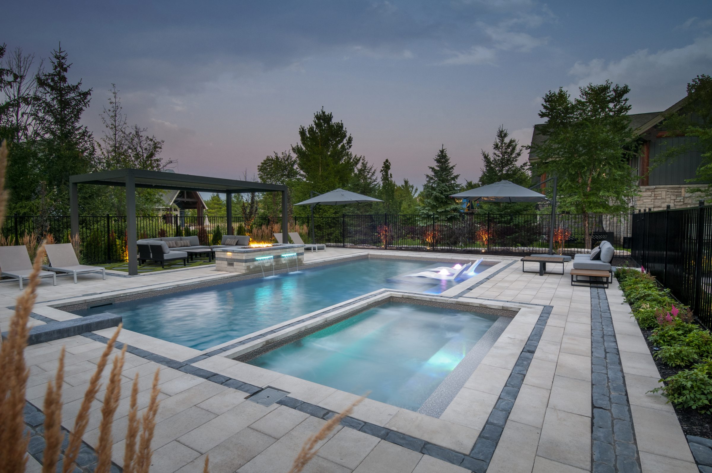 Modern backyard pool with spa and pergola