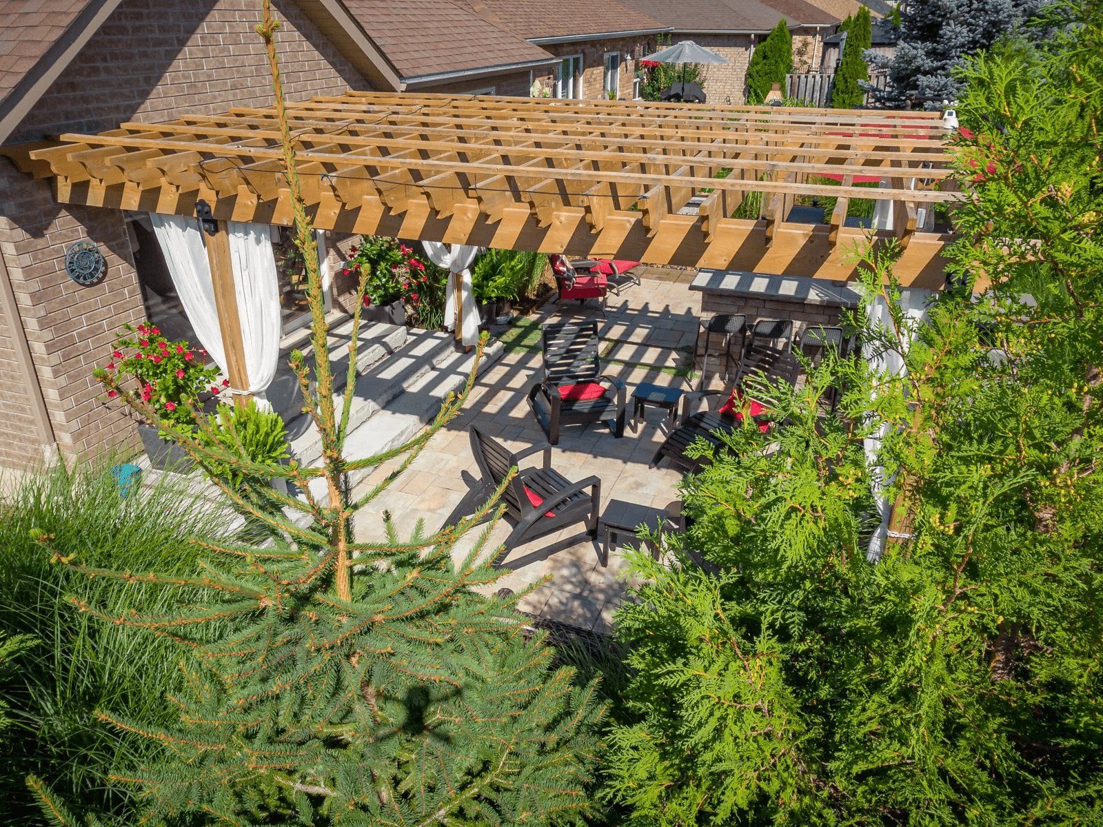 Backyard patio with wooden pergola and seating