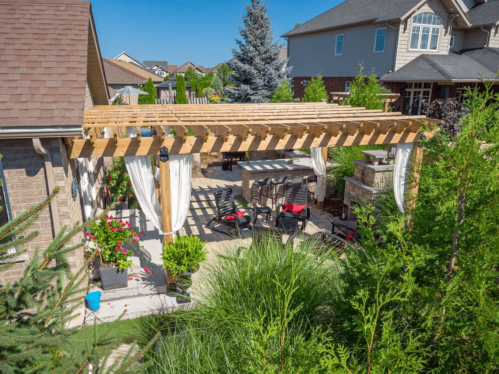 Backyard patio with wooden pergola and seating area