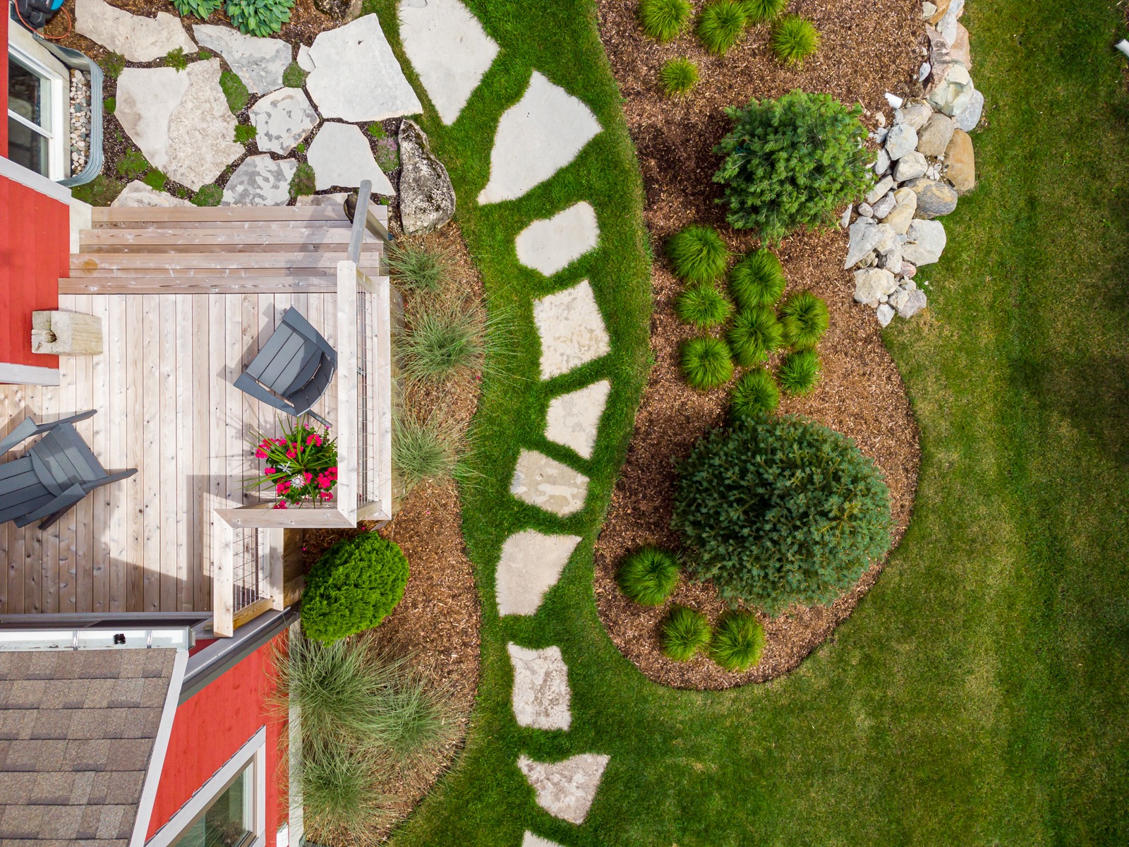 Aerial view of landscaped backyard with deck and pathway