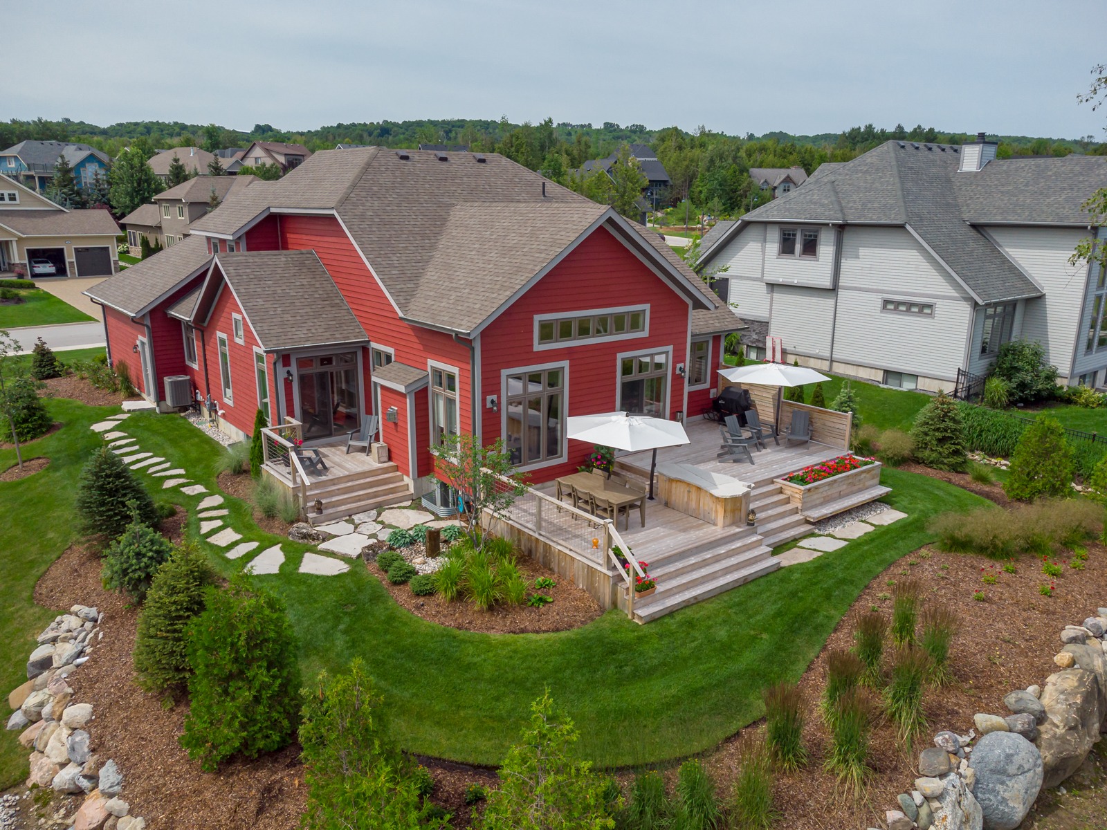 Red suburban home with large backyard deck