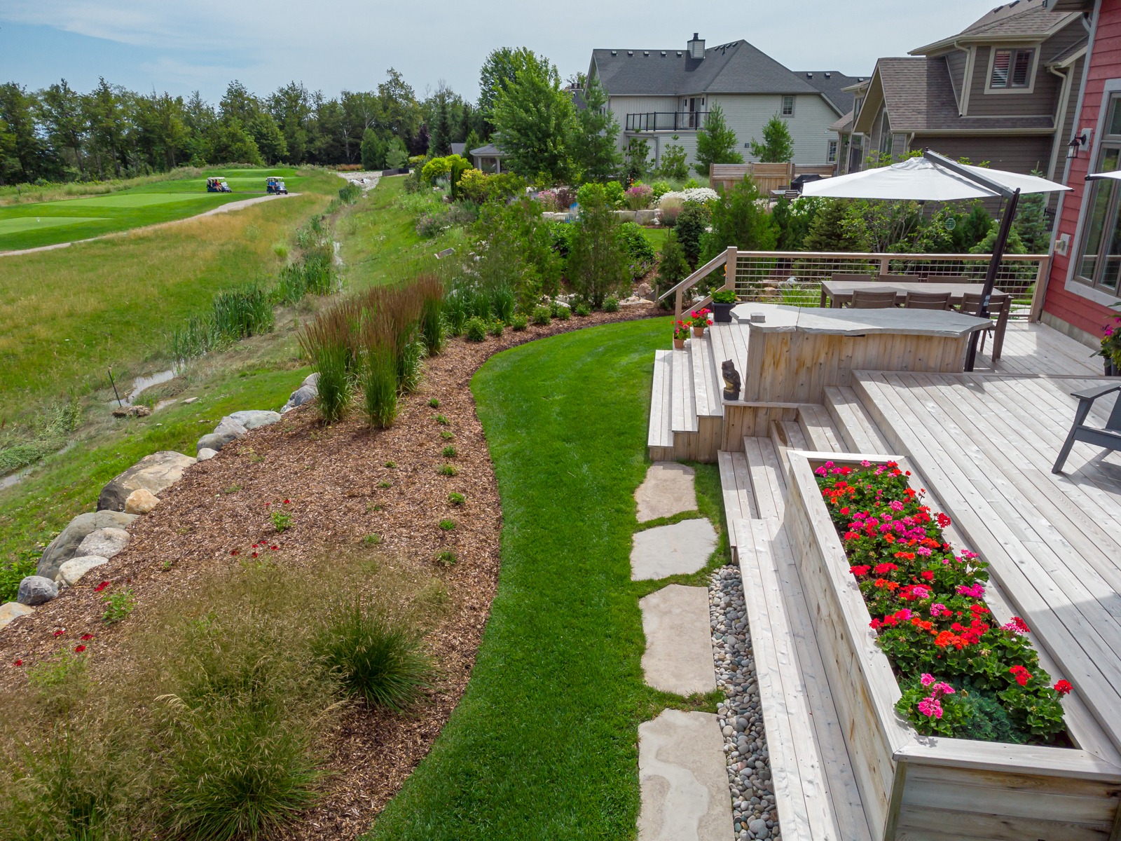Landscaped backyard deck overlooking golf course
