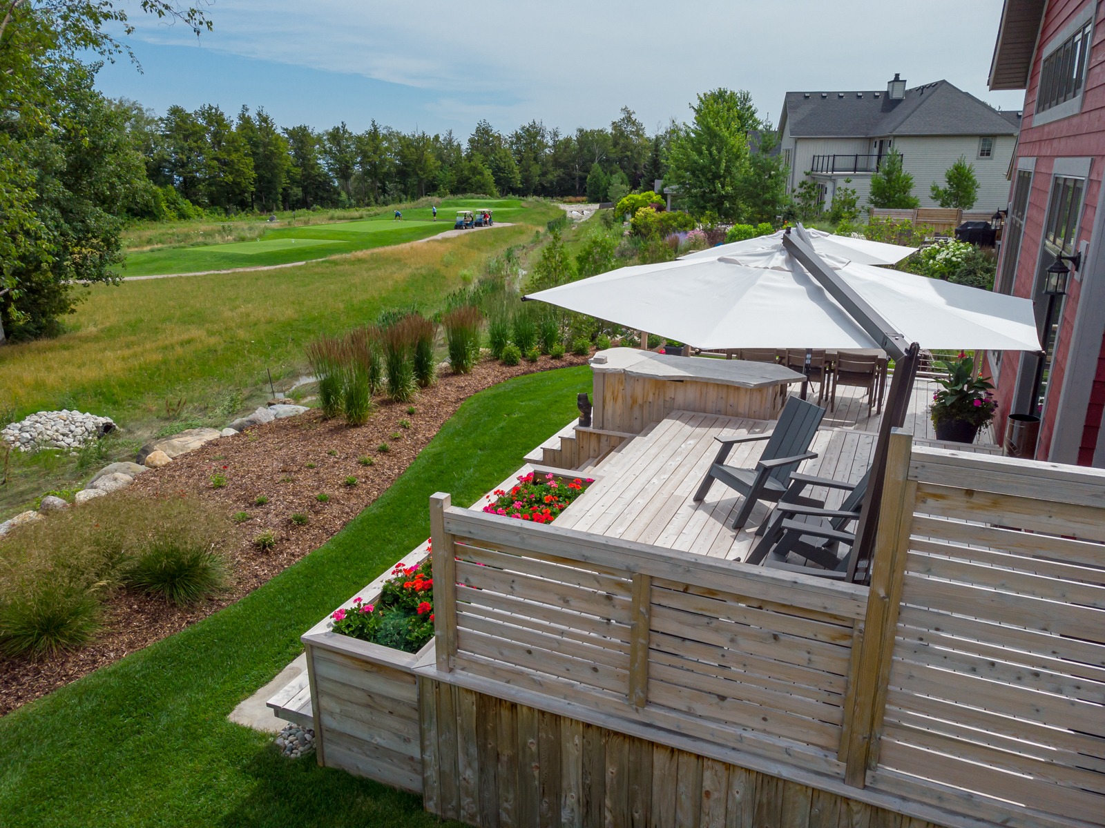 Backyard deck overlooking golf course and landscaped yard