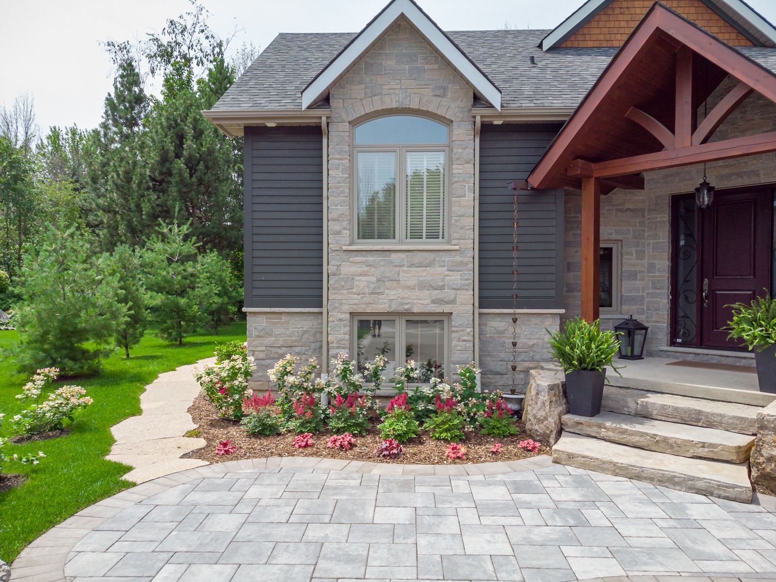 Modern stone house exterior with landscaped front yard