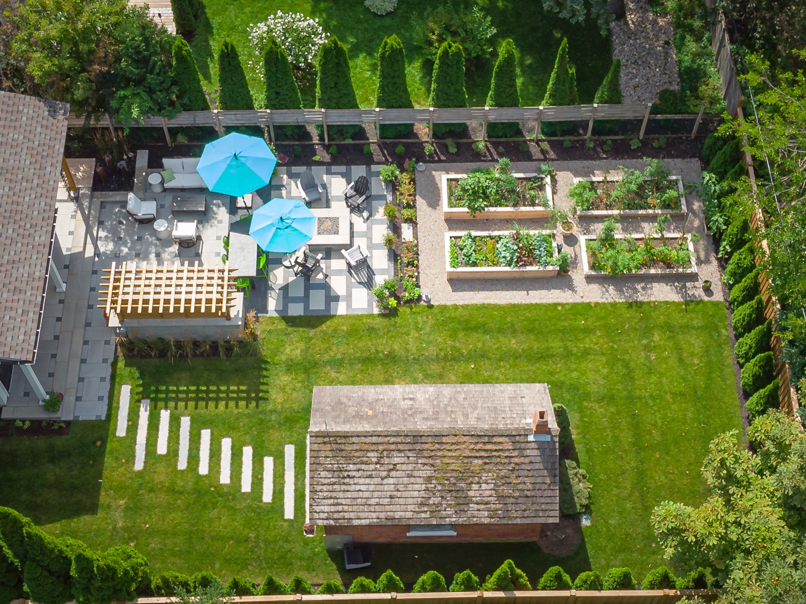 Aerial view of landscaped backyard with patio and garden beds