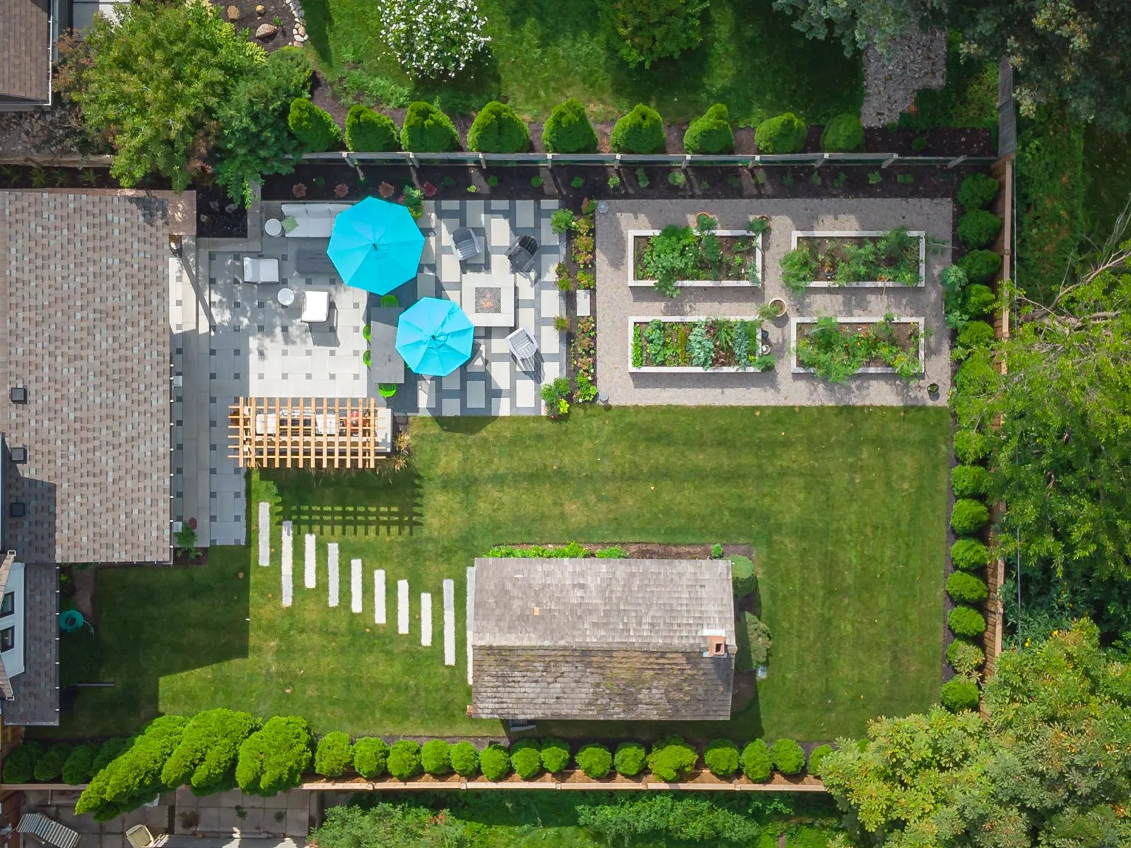 Aerial view of landscaped backyard with patio and garden