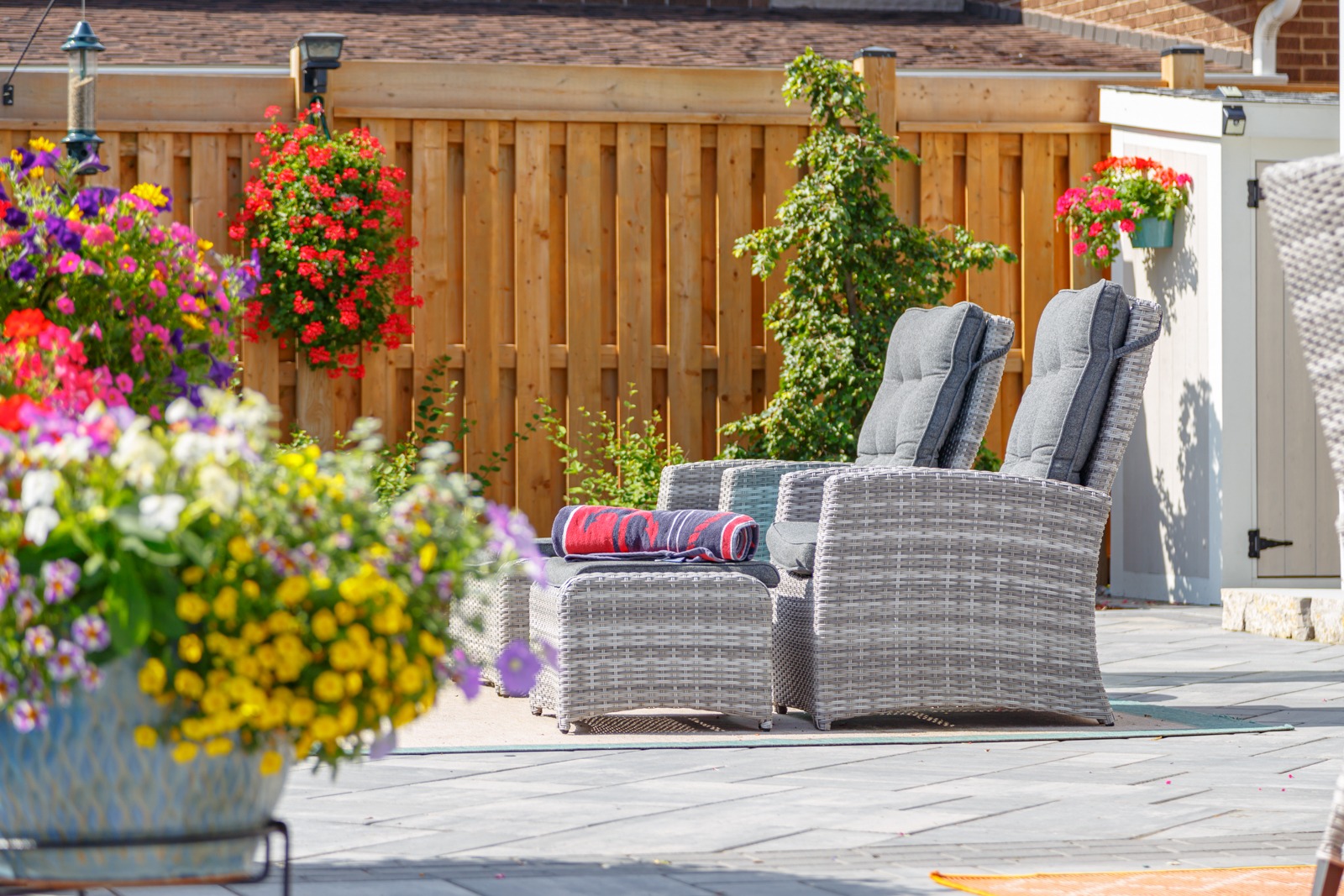 Cozy backyard patio with wicker chairs and flowers