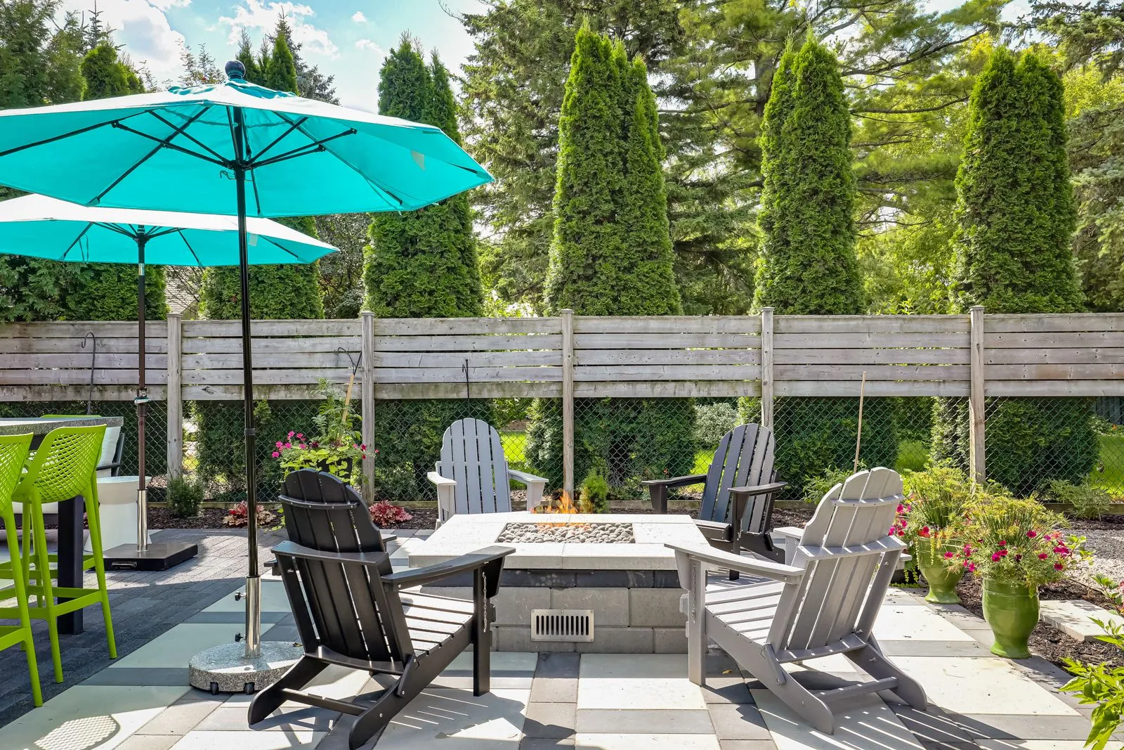 Backyard patio with fire pit and Adirondack chairs