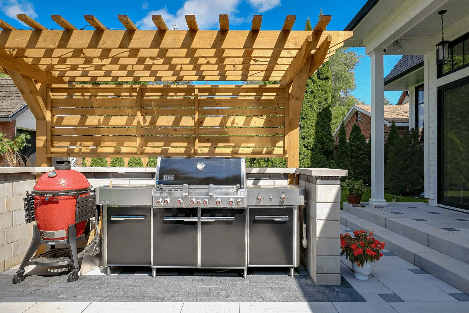 Outdoor kitchen with grill and wooden pergola