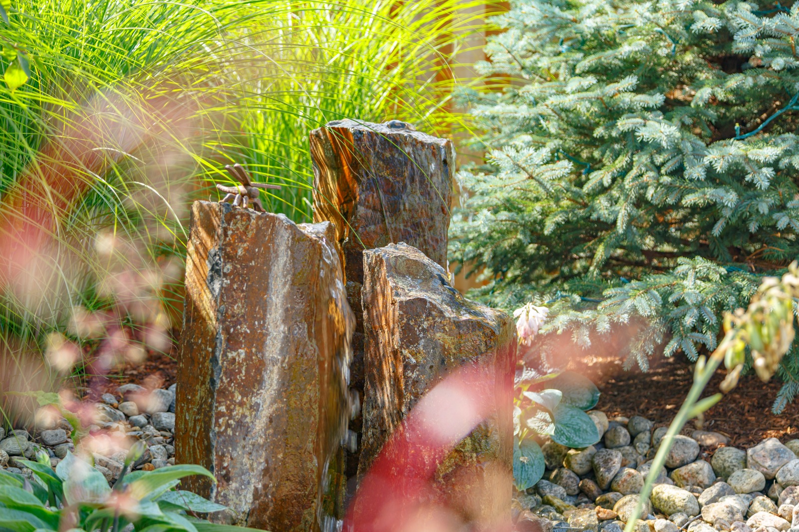 Stone garden fountain surrounded by lush greenery
