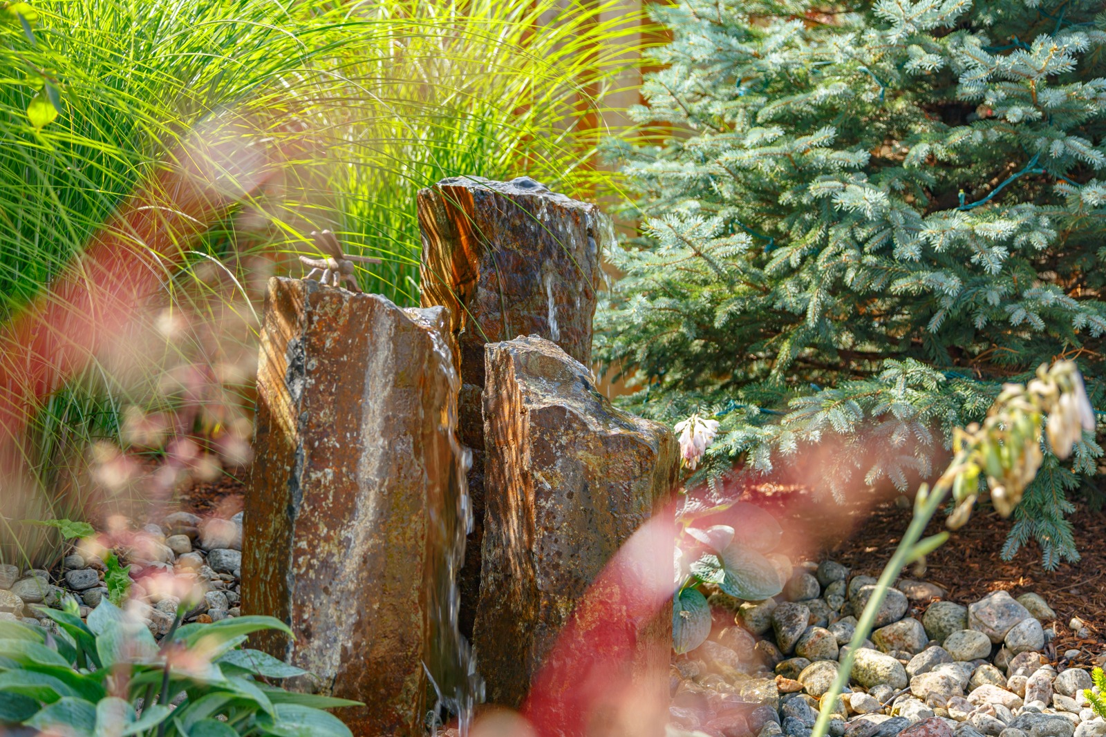 Stone garden fountain surrounded by lush greenery
