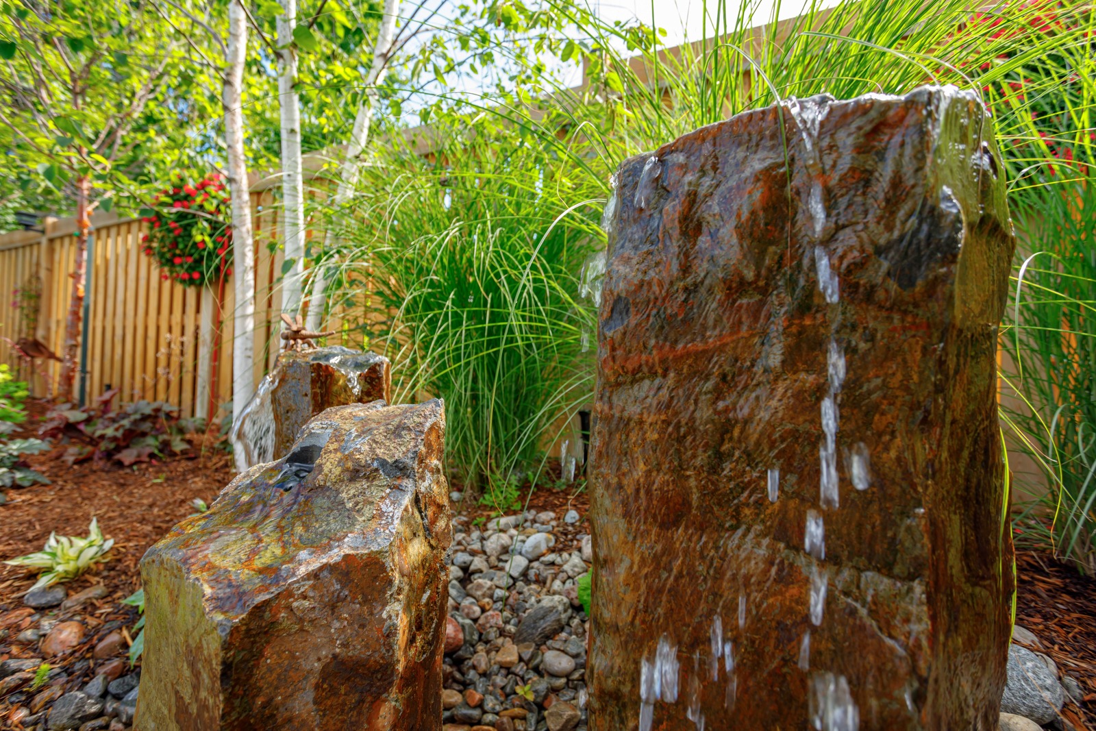 Stone water feature in landscaped backyard garden