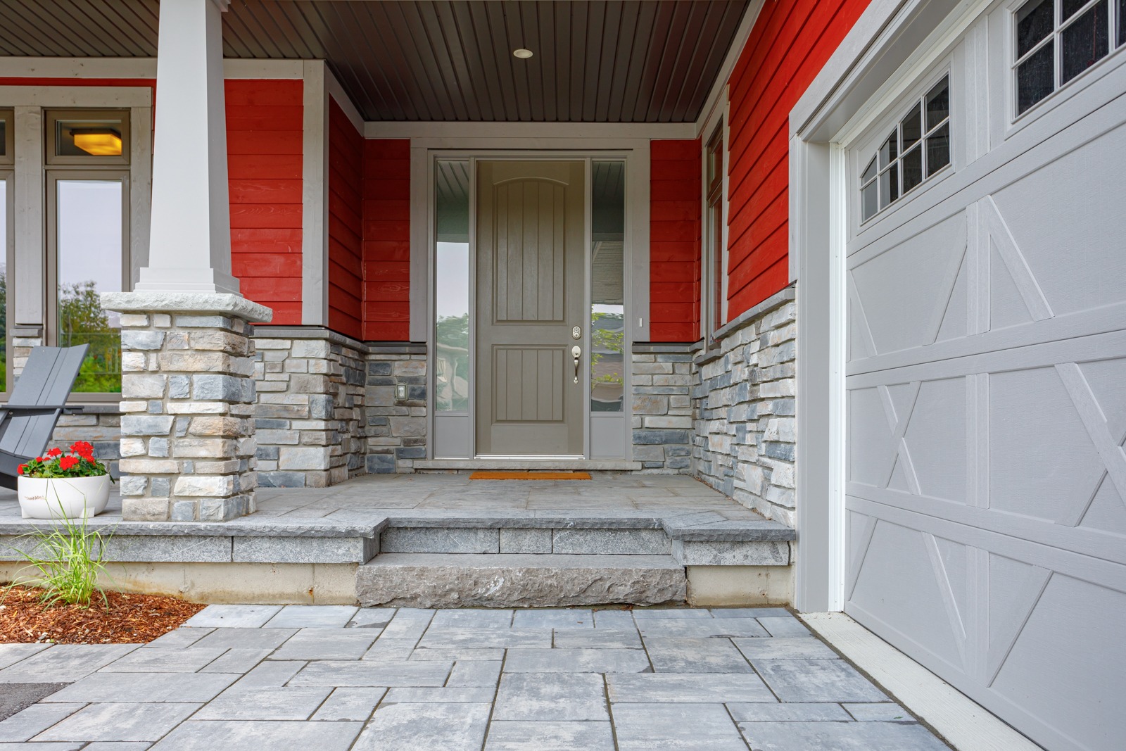 Modern home entrance with red siding and stone porch