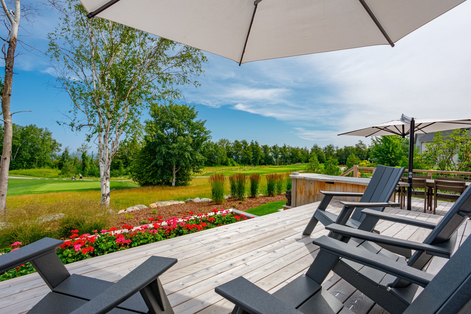 Wooden deck with chairs overlooking lush golf course