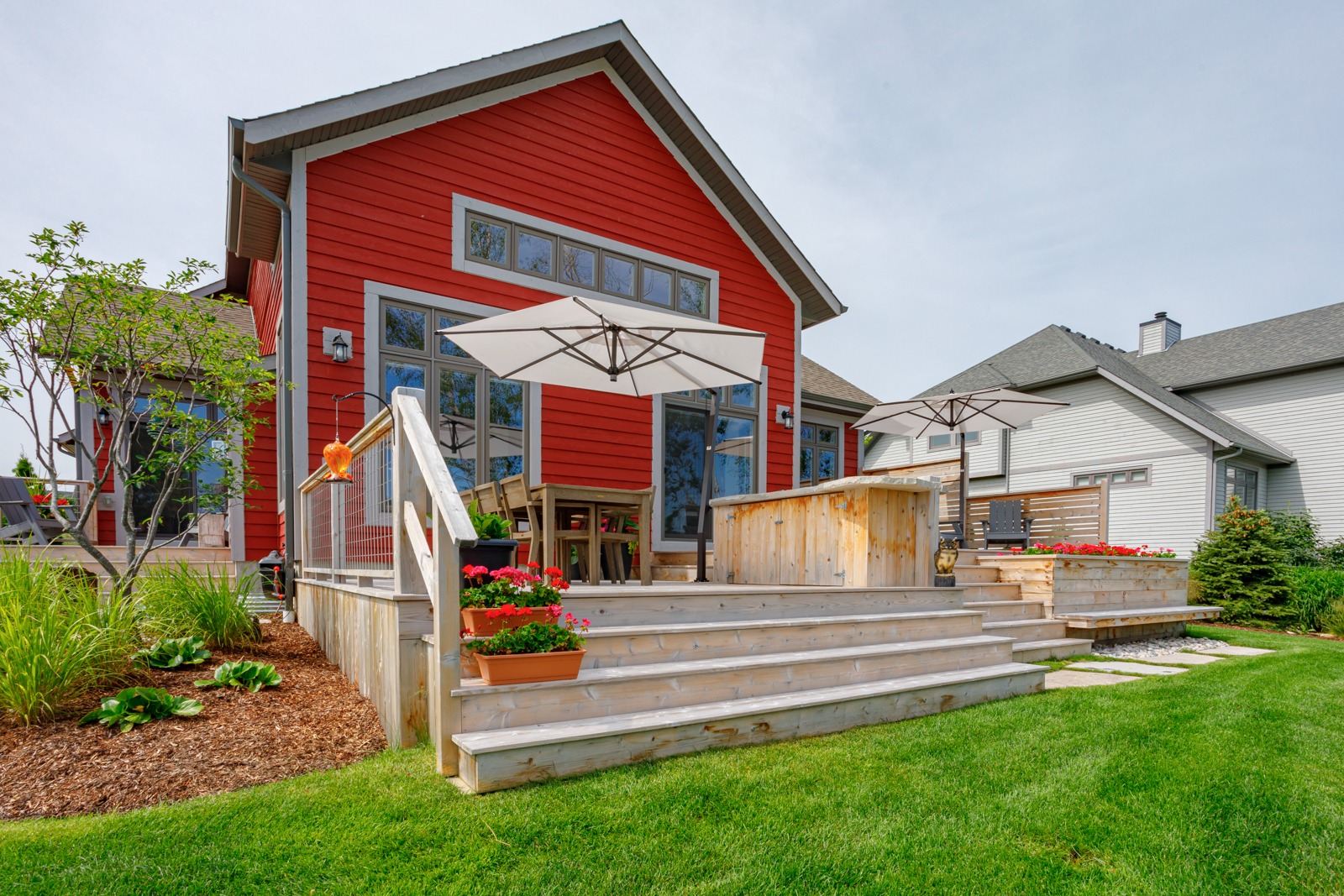 Modern red house with wooden backyard deck