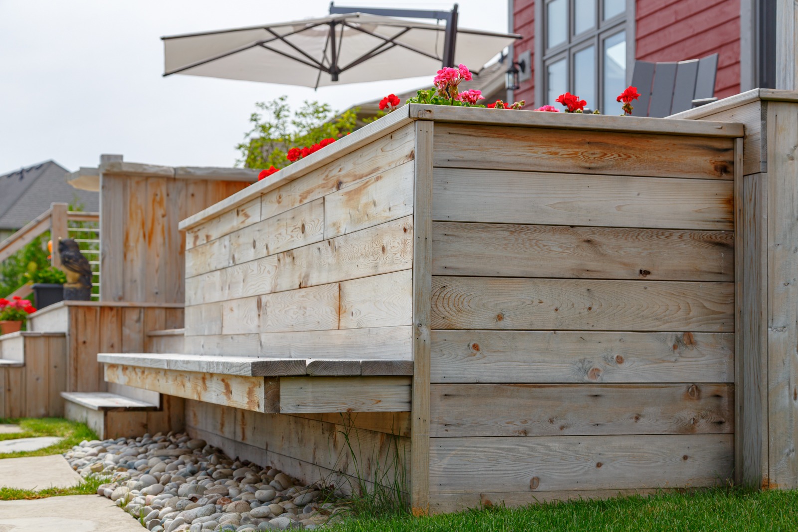 Wooden raised deck with built-in bench and flowers
