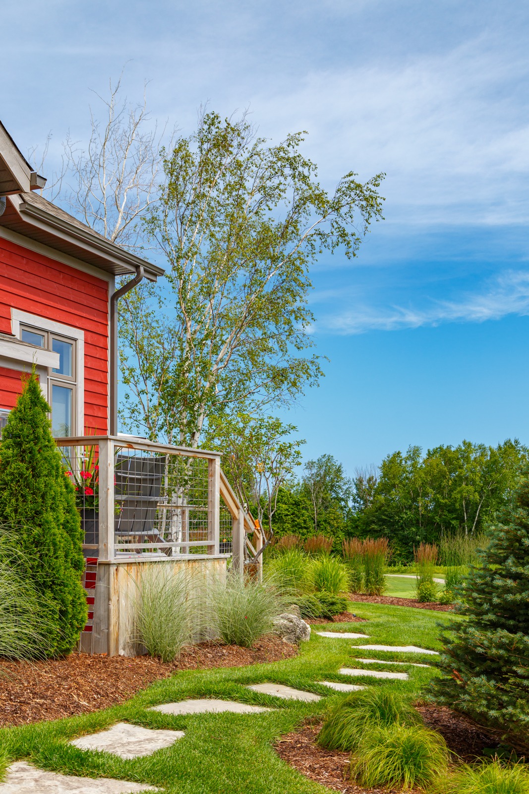 Red house with landscaped yard and stone path