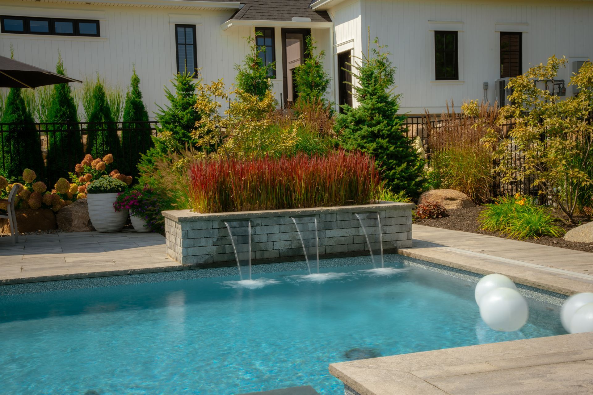 Modern backyard pool with stone waterfall feature