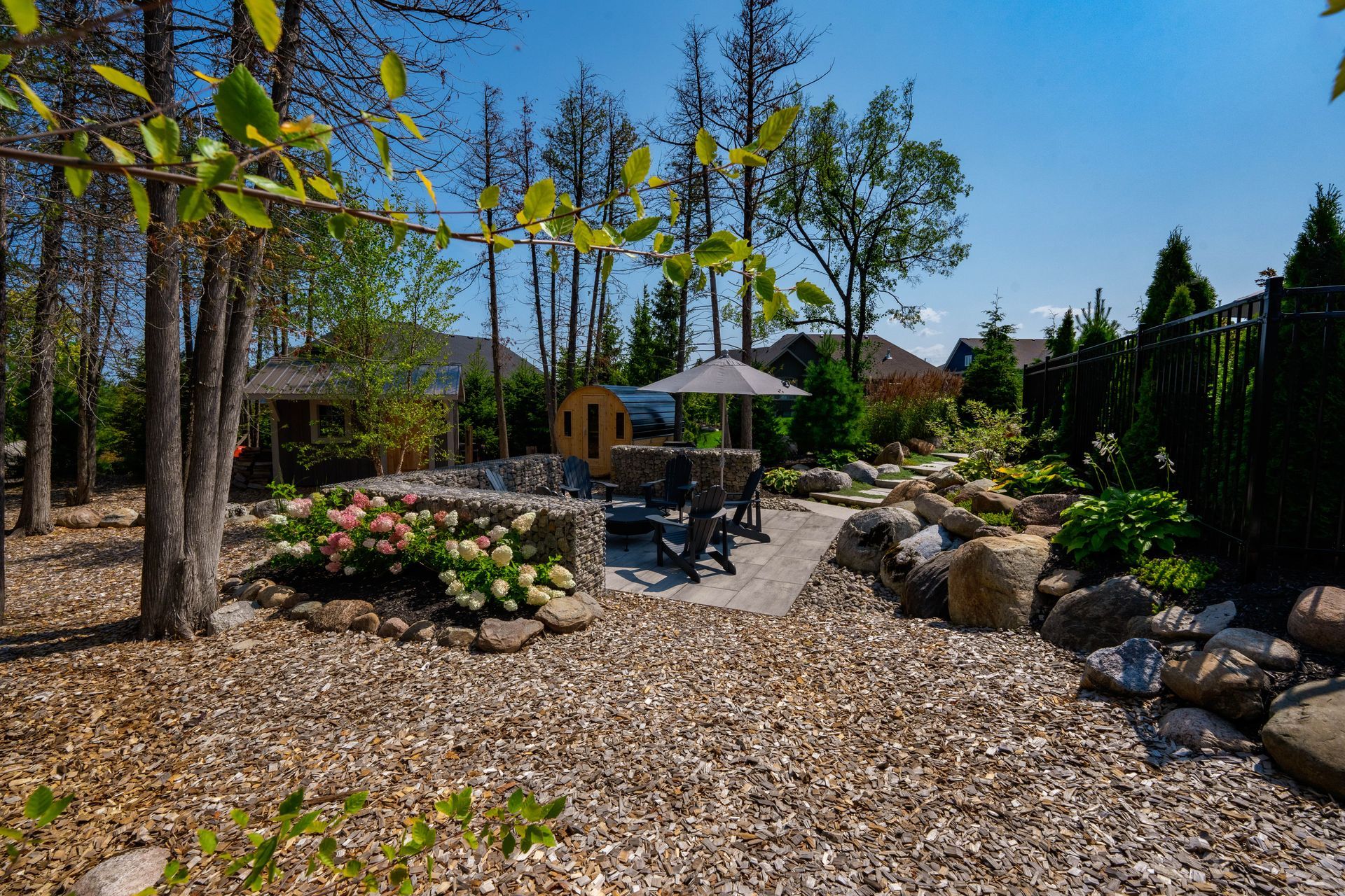 Landscaped backyard patio with seating and sauna