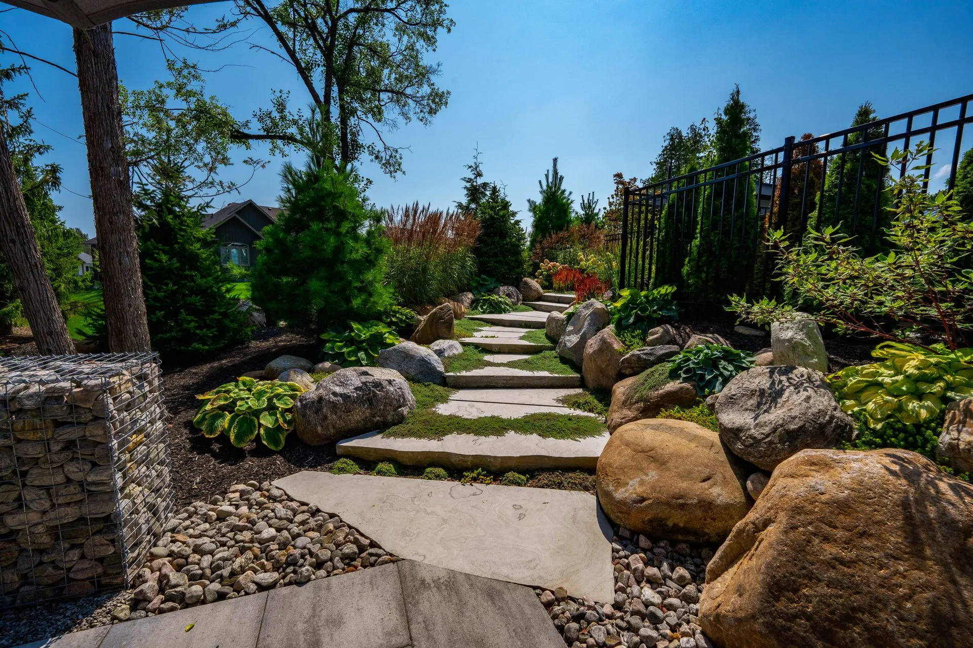 Stone garden pathway with landscaped plants and rocks