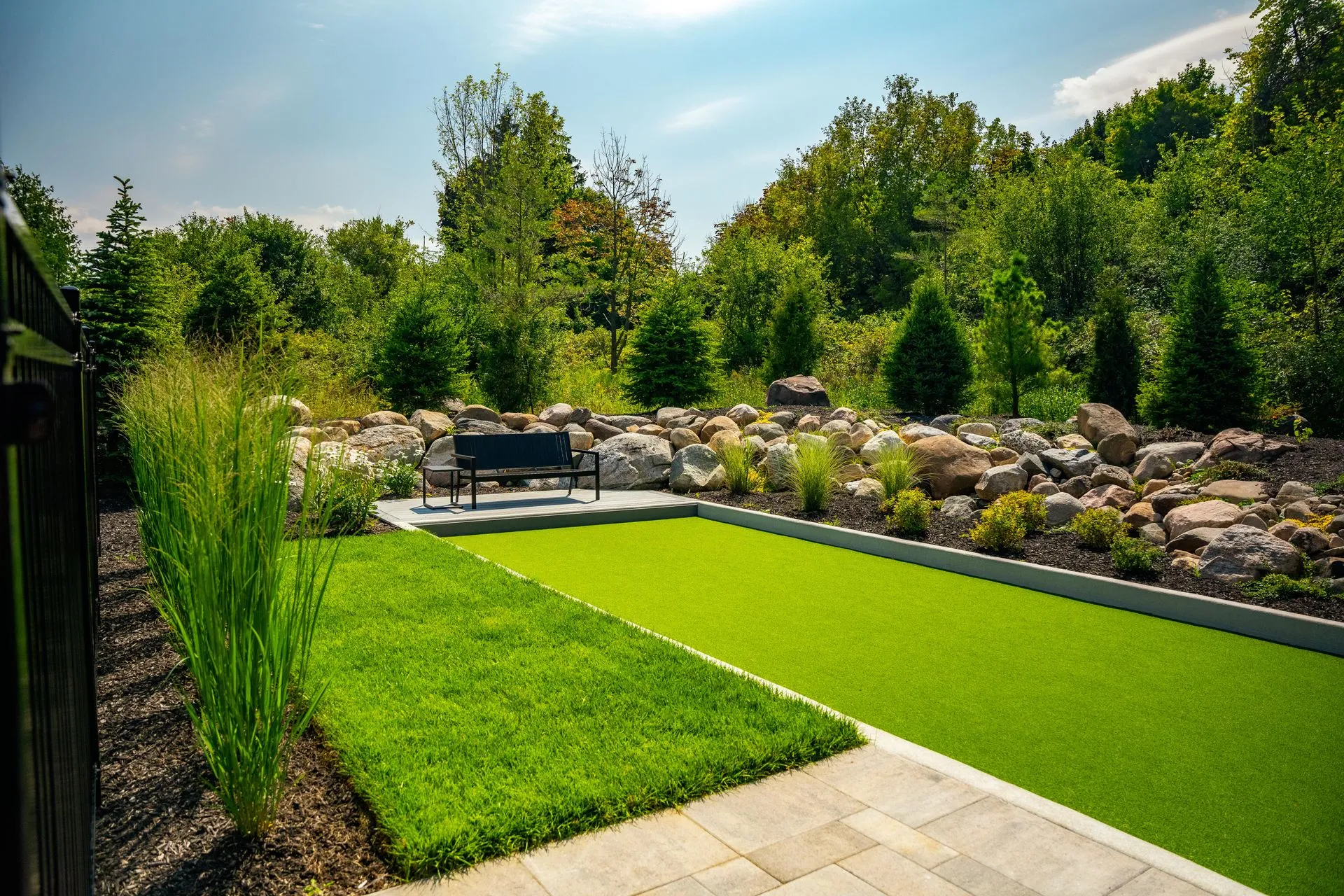 Landscaped backyard with artificial turf putting green