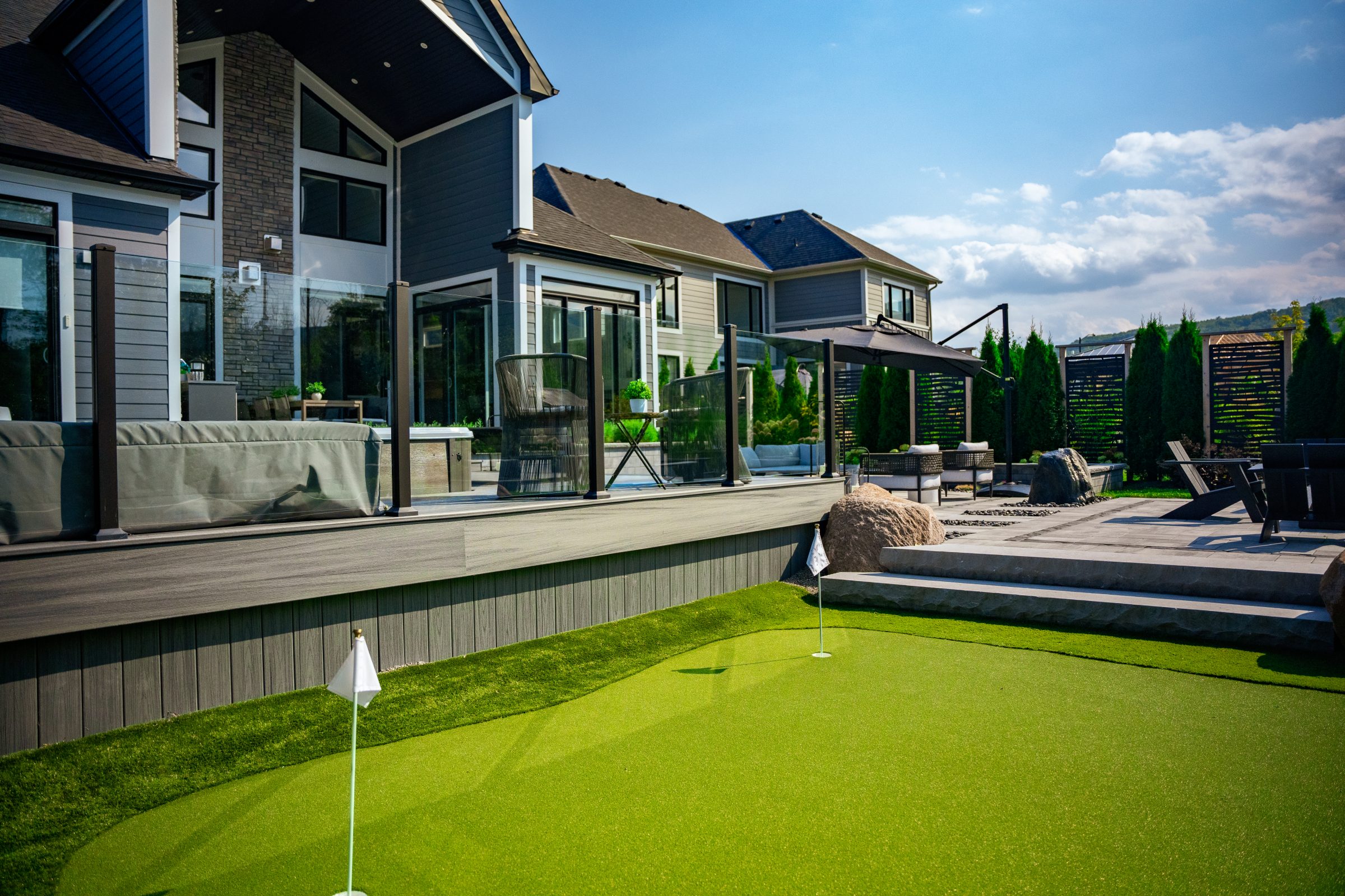 Modern backyard with deck and putting green