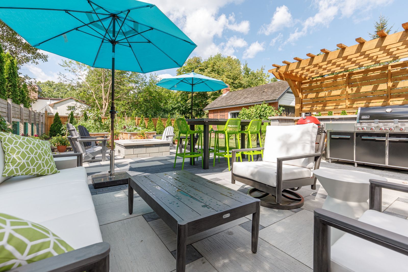 Modern backyard patio with umbrellas and grill