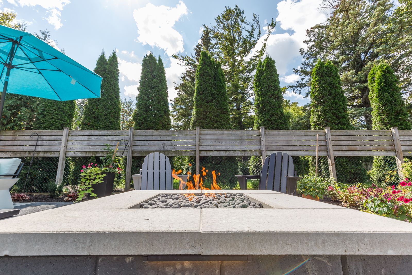 Modern backyard patio with fire pit and chairs