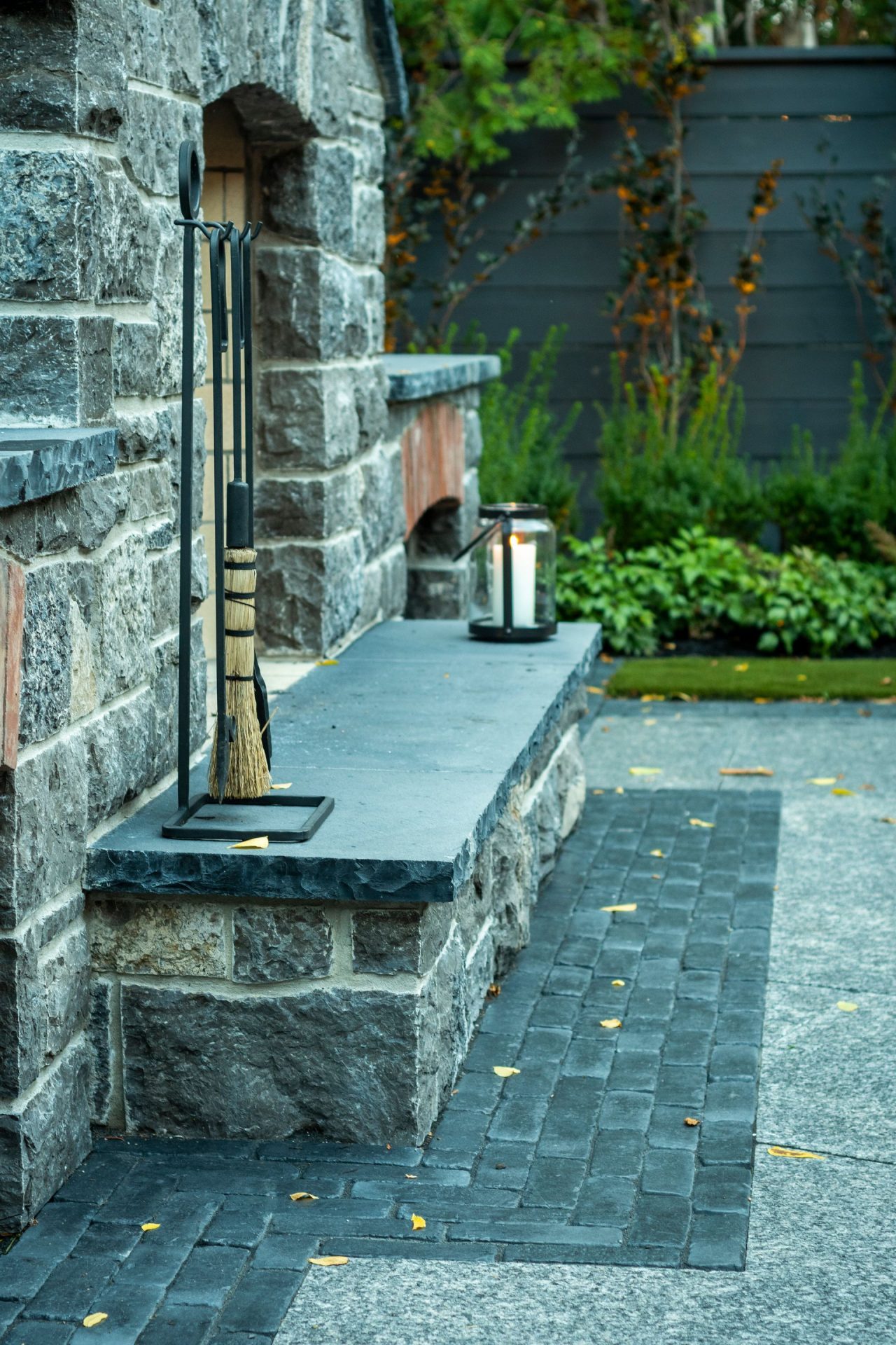 Stone outdoor fireplace with tools and lantern