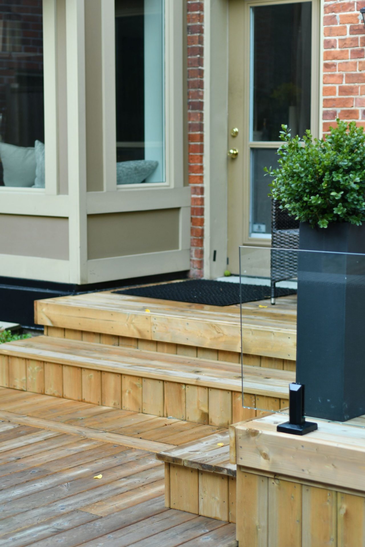 Wooden deck steps leading to brick house door