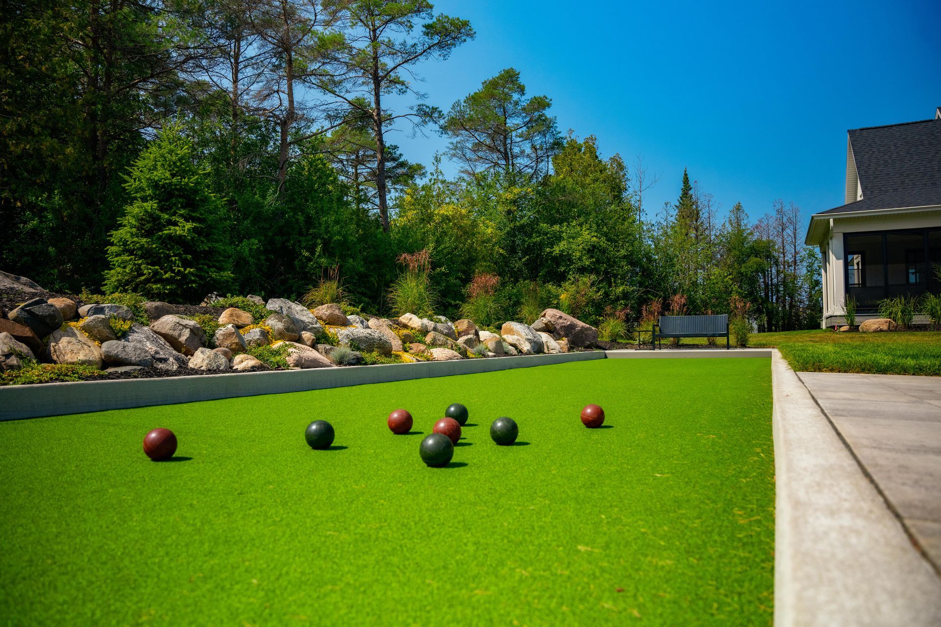 Backyard bocce ball court with landscaped garden