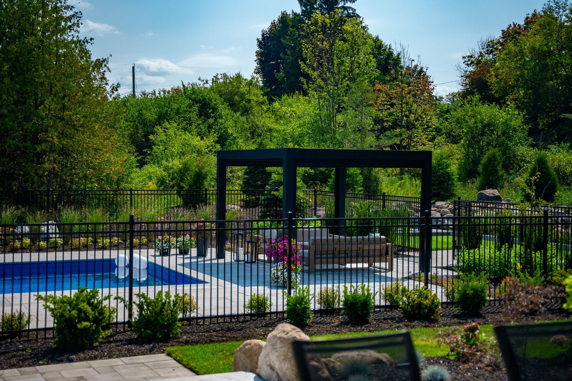 Modern backyard pool with pergola and garden landscaping