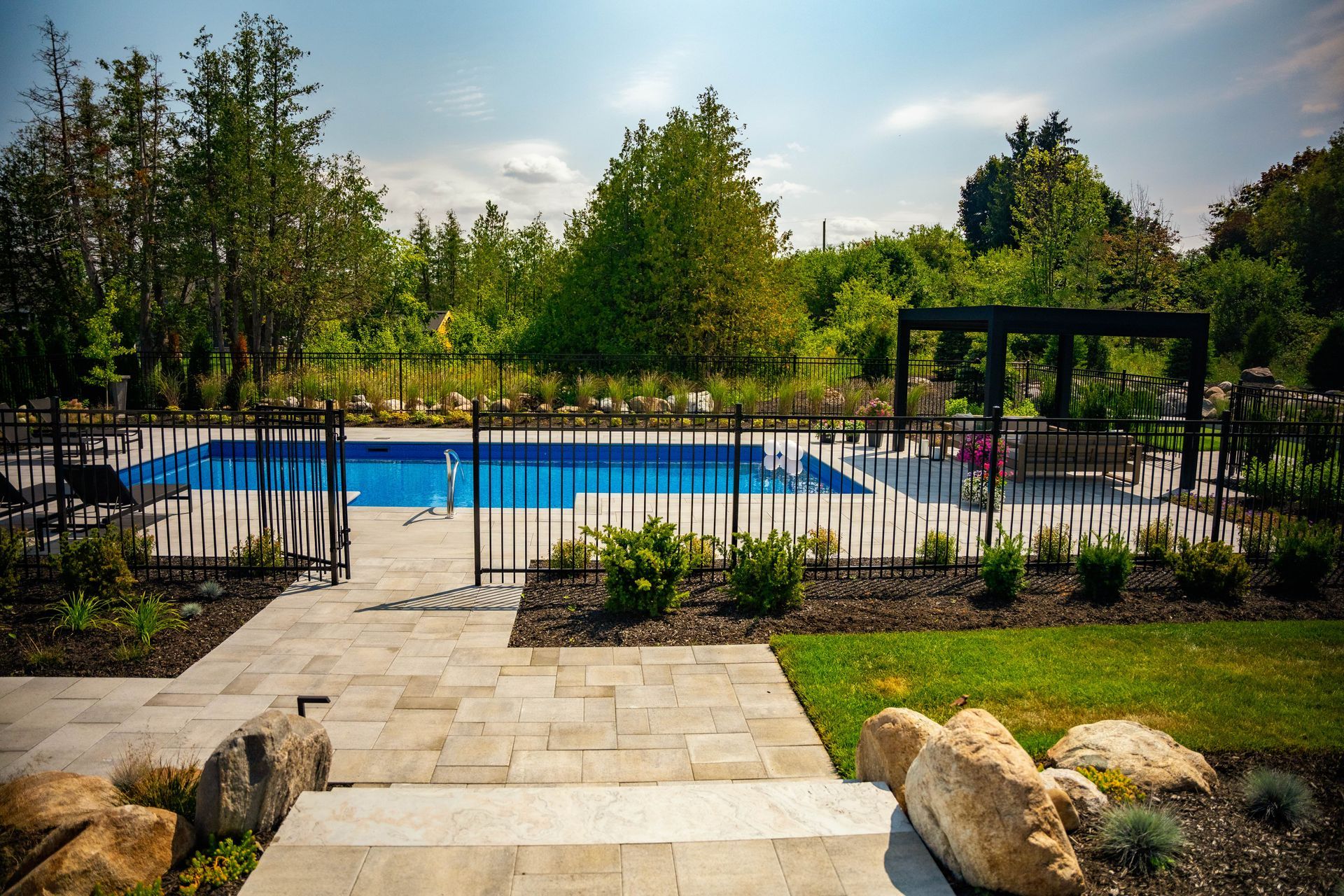 Landscaped backyard with fenced in-ground swimming pool